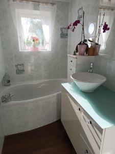 a bathroom with a white tub and a sink at Elise cornu in Mantry