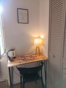 a desk with a lamp and a chair in a room at Elise cornu in Mantry