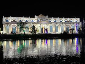 un gran edificio blanco con luces en el agua por la noche en Niagara Falls Bahawalpur, en Bahawalpur