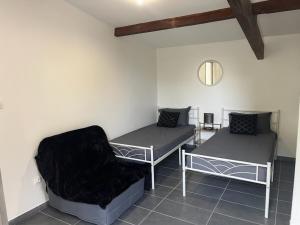 a room with two beds and a chair at Maison toute équipée à Grézieu la Varenne in Grézieu-la-Varenne +4 photos