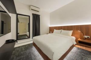 a bedroom with a large white bed and a mirror at STAYS HOTEL in Kuala Lumpur