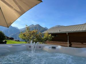 a hot tub with a fountain in front of a house at Sera Lodge in Grächen