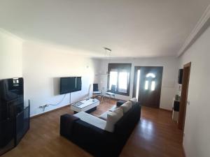 ein Wohnzimmer mit einem Sofa und einem TV in der Unterkunft Casa Vera in A Guarda