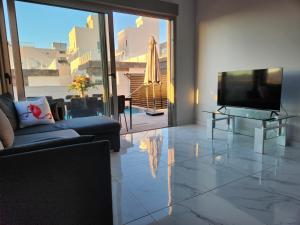 een woonkamer met een televisie en een bank bij Fee4Me 2 Bedroom House with Private Pool and Rooftop Terrace in Alicante