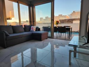 uma sala de estar com um sofá e uma mesa em Fee4Me 2 Bedroom House with Private Pool and Rooftop Terrace em Alicante
