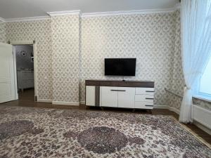 ein Wohnzimmer mit einem TV an der Wand in der Unterkunft 2-х комнатная квартира в ЖК Заман in Atyrau