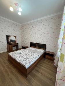 Schlafzimmer mit einem Bett und einem Spiegel in der Unterkunft 2-х комнатная квартира в ЖК Заман in Atyrau