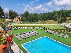 a pool with chaise lounge chairs and a bunch ofitures at Apartman KUTIJA Kopaonik in Kopaonik