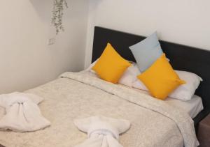Una cama con almohadas amarillas y blancas. en Moranit, en Moran