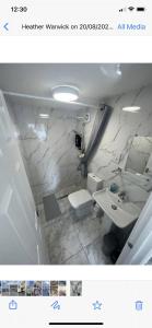 a white bathroom with a sink and a toilet at Tranquil Escape in Tilehurst