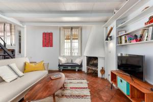 a living room with a couch and a tv at A relaxed bohemian vibe in Old town in Marbella
