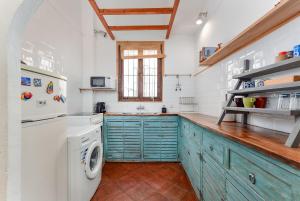 a kitchen with blue cabinets and a washer and dryer at A relaxed bohemian vibe in Old town in Marbella