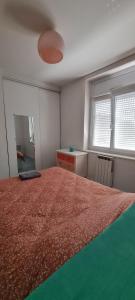 een slaapkamer met een groot bed en een rode deken bij La brique rouge - Maison 66 m2 avec 2 chambres in Lille