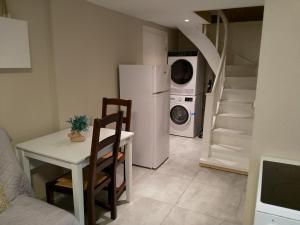 uma cozinha com uma mesa, um frigorífico branco e escadas em 2 Bedrooms Furnished Semi-basement Apartment - close to everything in Moss em Moss