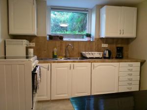 a kitchen with white cabinets and a sink and a window at 2 Bedrooms Furnished Apartment - Close to everything in Moss in Moss +11 photos