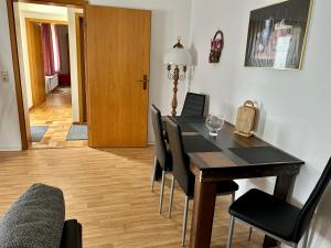 a dining room with a black table and chairs at Ferienwohnung Tannhäuser in Braunlage