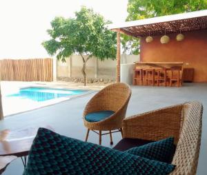 eine Terrasse mit 2 Stühlen, einem Tisch und einem Pool in der Unterkunft Matumaini Guest House in Migogoni
