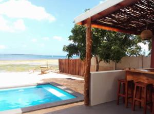 una piscina con bar y la playa en Matumaini Guest House, en Migogoni