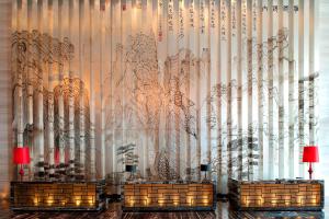 青島的住宿－青島富力艾美酒店，一间有一面墙的房间,里面有树木的雕塑