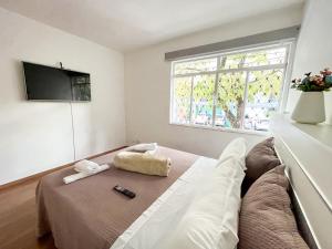 uma sala de estar com um sofá e uma televisão em Apartamento em Belo Horizonte em Belo Horizonte