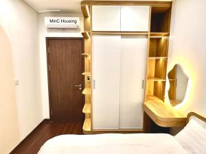 Kleines Zimmer mit einem Bett und einer Holztür in der Unterkunft MinC Housing in Hanoi