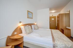 1 dormitorio con 1 cama grande y cabecero de madera en Kini Park Hotel All Inclusive & Free Parking en Golden Sands