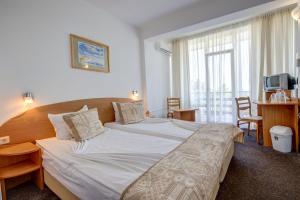 Un pat sau paturi într-o cameră la Kini Park Hotel All Inclusive & Free Parking