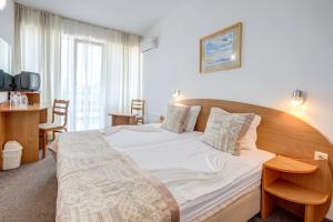 um quarto com uma cama grande e uma cabeceira em madeira em Kini Park Hotel All Inclusive & Free Parking em Golden Sands