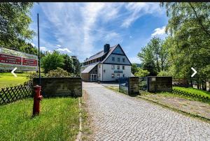 una boca de incendios roja frente a una casa blanca en Hostel im Osterzgebirge, en Kurort Altenberg