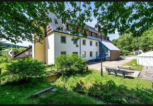 a large white building with a bench in front of it at Hostel im Osterzgebirge in Kurort Altenberg