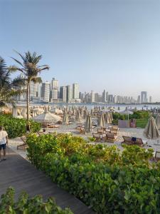 a beach with umbrellas and chairs and a city at 7 Palm Jumeirah in Dubai