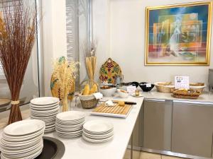 a kitchen with white plates on a counter at Anesis Hotel in Ayia Napa