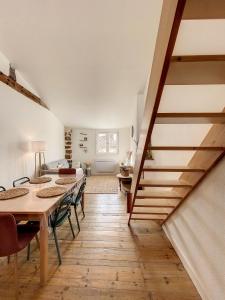 Habitación con mesa, sillas y escalera. en Maison atypique - centre historique - Puy en Velay, en Le Puy en Velay