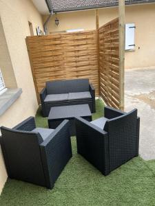 eine Terrasse mit 3 Korbstühlen und einer Couch in der Unterkunft Appartement Cosy au cœur de la Champagne in Cramant