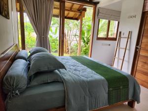 Schlafzimmer mit einem großen Bett und einem Fenster in der Unterkunft Villa Francindo in Uluwatu