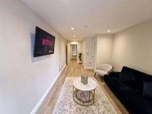 - un salon avec un canapé et une télévision murale dans l'établissement Aire Apartments (Central) - Executive City Center Apartments, à Leeds