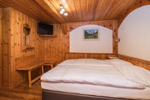 ein Schlafzimmer mit einem Bett in einem Holzzimmer in der Unterkunft Hotel Taescherhof in Täsch