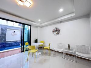 une salle à manger avec des chaises jaunes et une table dans l'établissement โรงแรม ชม เชียงราย, à Ban Hua Khwai (1)