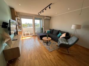 Turquoise Apartment (Private Garage) في نوفي ساد: غرفة معيشة مع أريكة وطاولة
