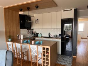 Turquoise Apartment (Private Garage) في نوفي ساد: مطبخ مع كونتر وجزيرة مع كراسي بار