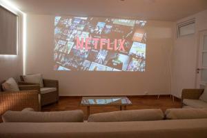 a living room with couches and a large screen at Can Carles - Delta del Ebro in El Poblenou del Delta
