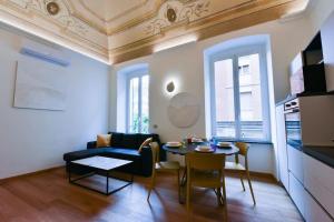 ein Wohnzimmer mit einem blauen Sofa und einem Tisch in der Unterkunft Loft 21 - Lussuoso ed Elegante a due passi dal Mare in Finale Ligure