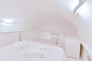 a white room with a bed with towels on it at Loft 21 - Lussuoso ed Elegante a due passi dal Mare in Finale Ligure