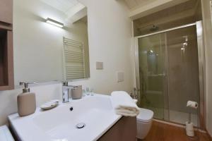 ein Badezimmer mit einem weißen Waschbecken und einer Dusche in der Unterkunft Loft 21 - Lussuoso ed Elegante a due passi dal Mare in Finale Ligure