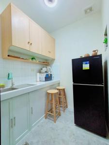 a kitchen with a black refrigerator and a sink at 6 - Affordable 2-Storey House in Cabanatuan City in Cabanatuan