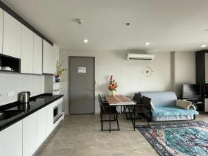 a kitchen and living room with a table and a couch at The Base Infinity in Pattaya Central