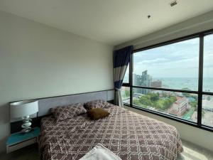 a bedroom with a bed and a large window at The Base Infinity in Pattaya Central