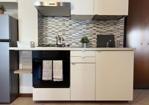una cucina con forno a piano cottura in bianco e nero di Appartamento Il Girasole a Terni, Umbria a Terni