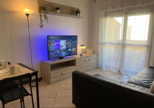 een woonkamer met een bank en een televisie bij Appartamento Il Girasole a Terni, Umbria in Terni