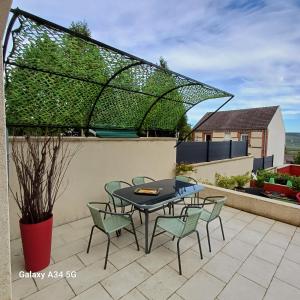 a patio with a table and chairs on a roof at Esterline in Hautvillers